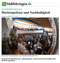 A crowd of people in a school gym; everyone is looking intently ahead