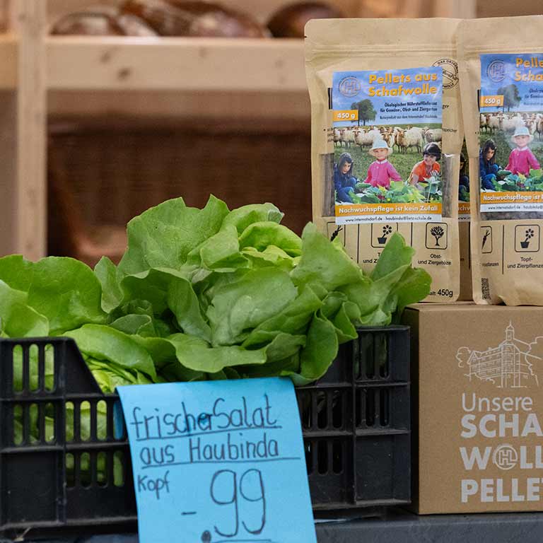Lettuce and pellets in a store with a handwritten price tag