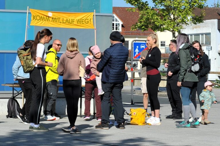 Eine Gruppe Menschen steht bei einer Veranstaltung mit gelbem Banner zusammen
