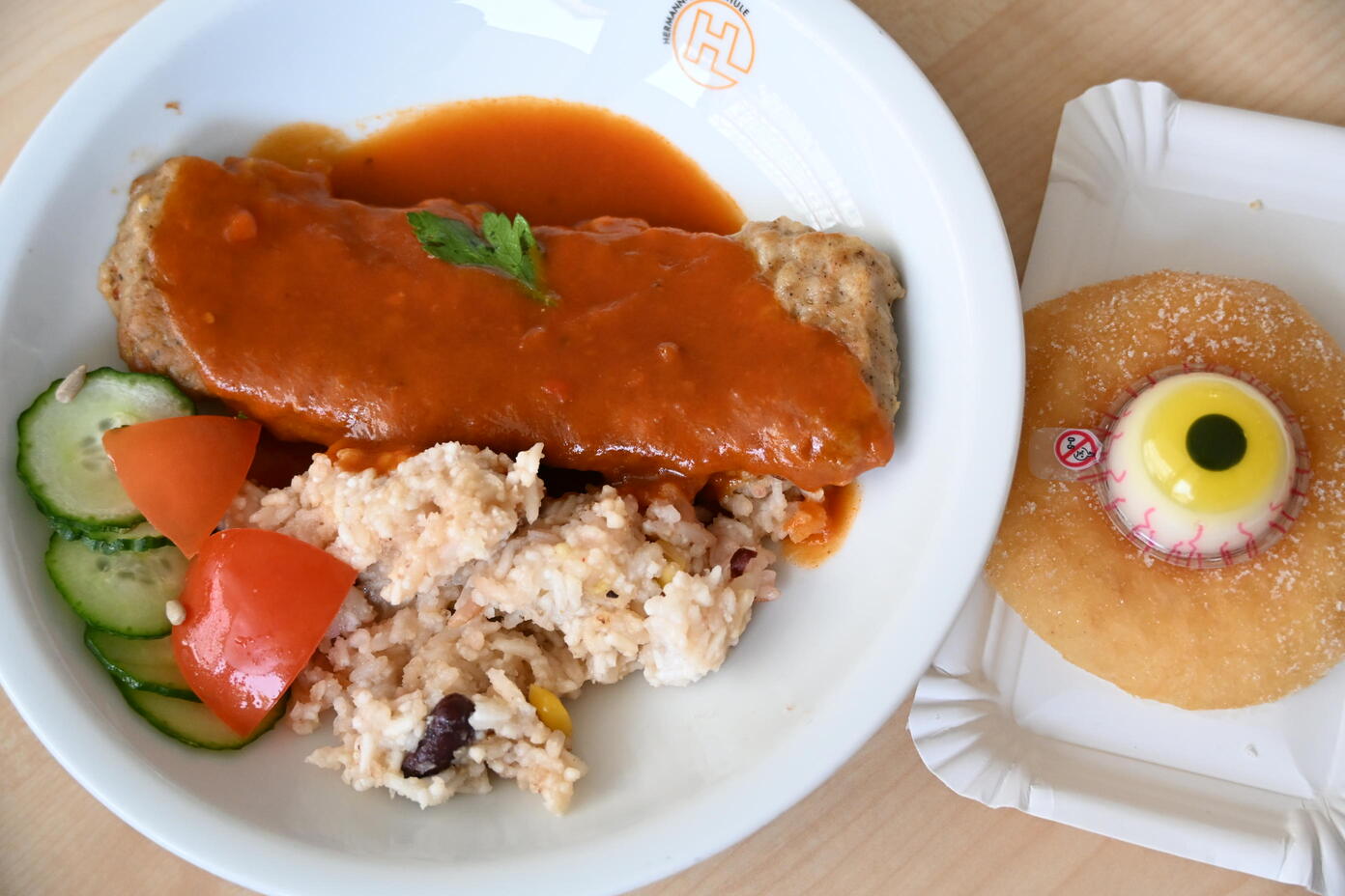 Teller mit Frikadelle in Tomatensauce, Reis, Gurken und Dessert mit Fruchtkern