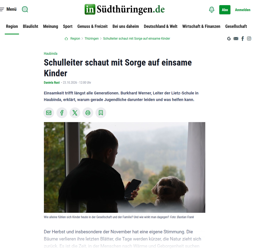Ein Kind mit Smartphone und ein Hund blicken als Silhouette aus dem Fenster
